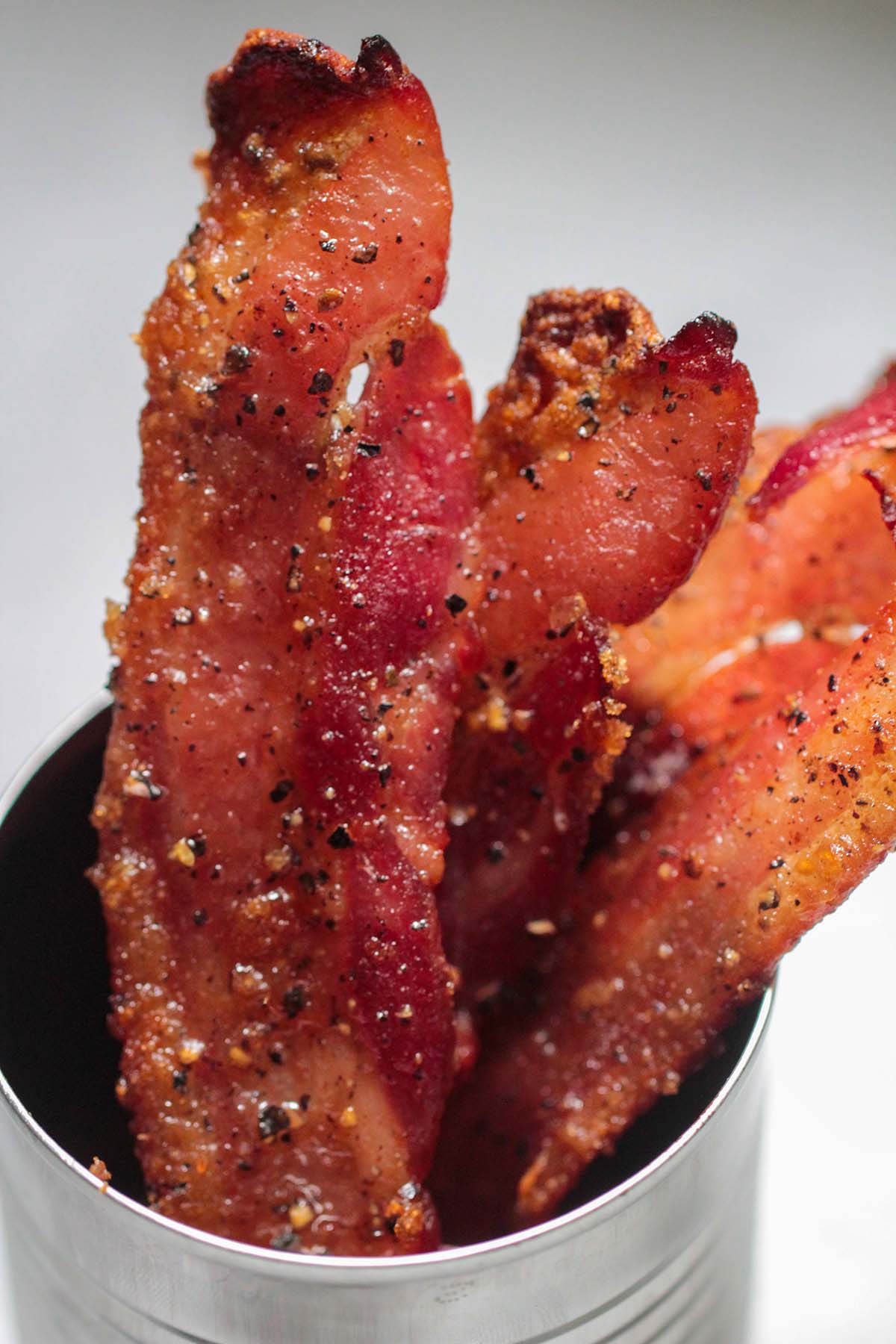 strips of candied bacon in a cup. 