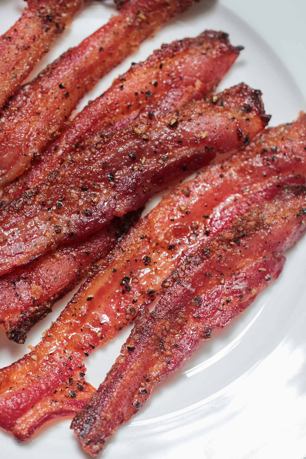 cooked candied bacon on a white plate. 