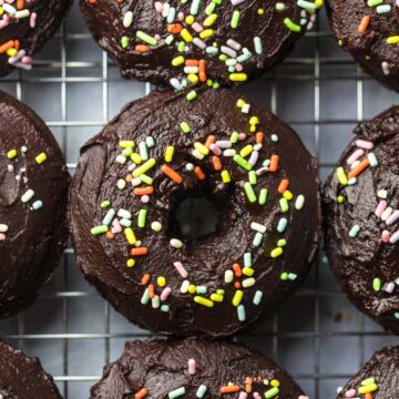baked chocolate donuts with sprinkles up close.