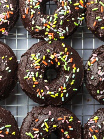 baked chocolate donuts with sprinkles up close.