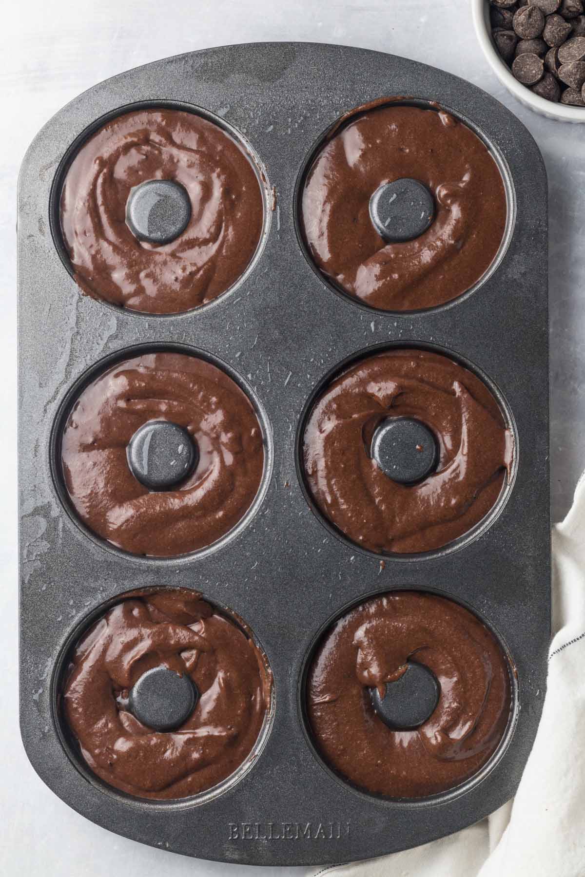 donut mold filled with chocolate cake batter. 