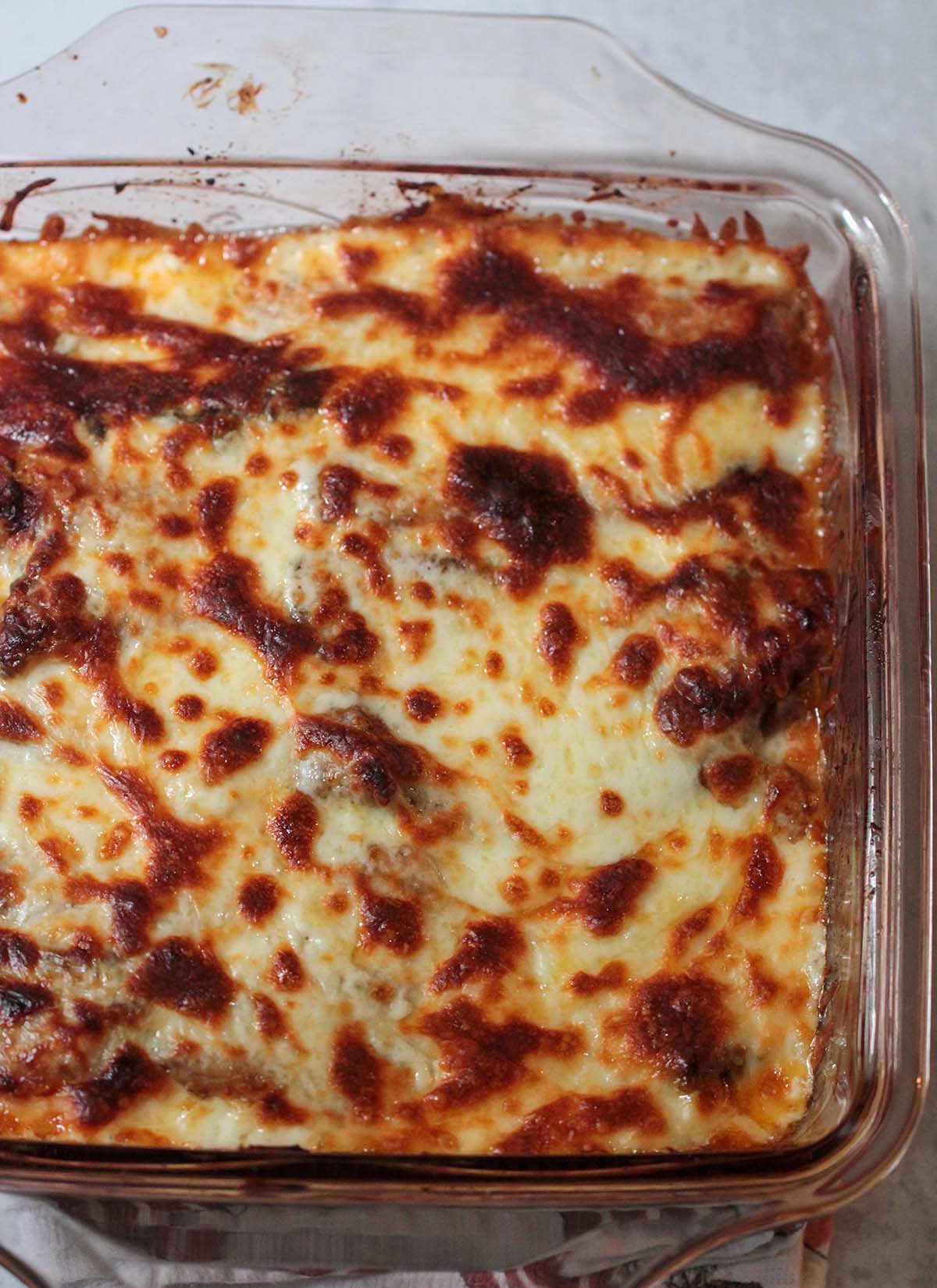 pastelon with platano maduro in a baking dish. Covered with melted cheese.