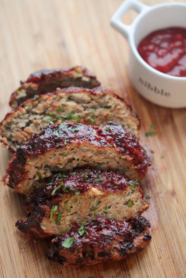 sliced meatloaf on a wooden board.