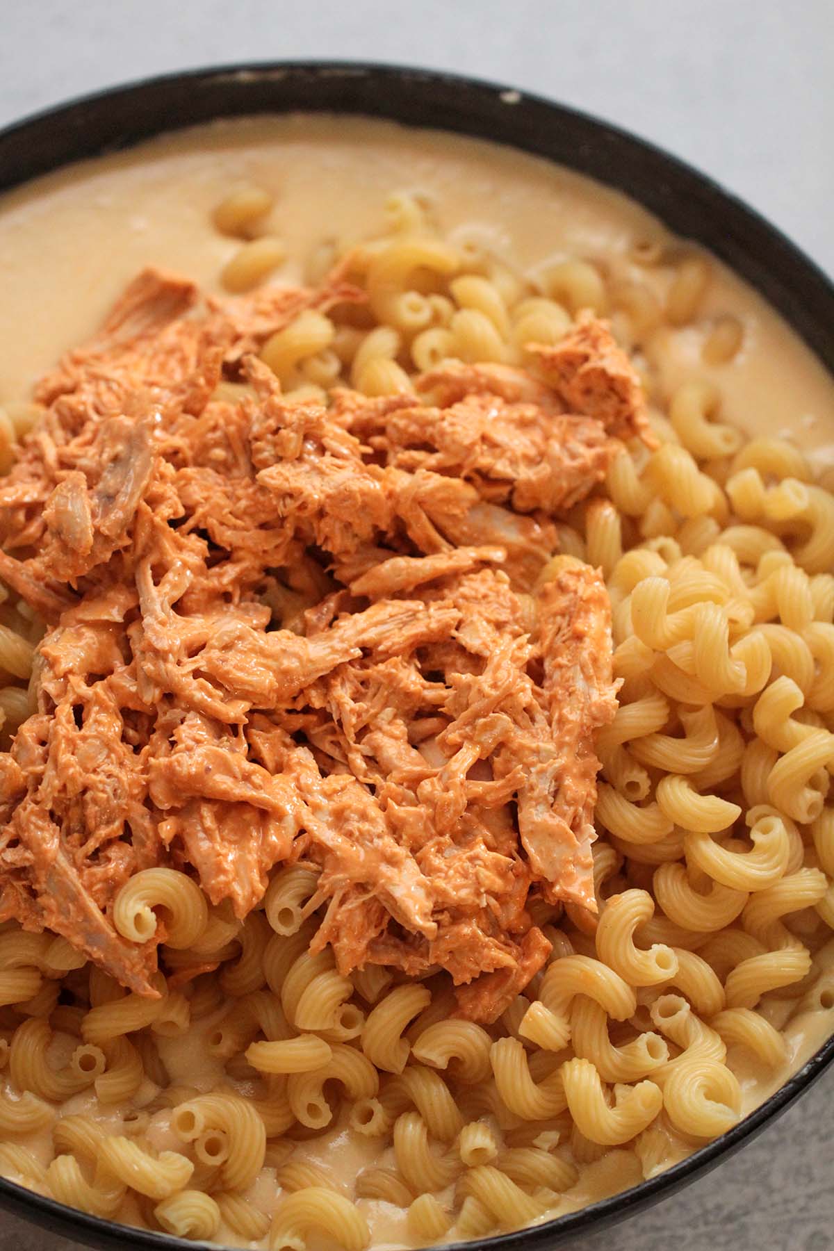 a mixture of cooked pasta, buffalo chicken, and cheese sauce. 
