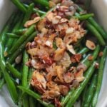 green beans almondine in a white dish up close.