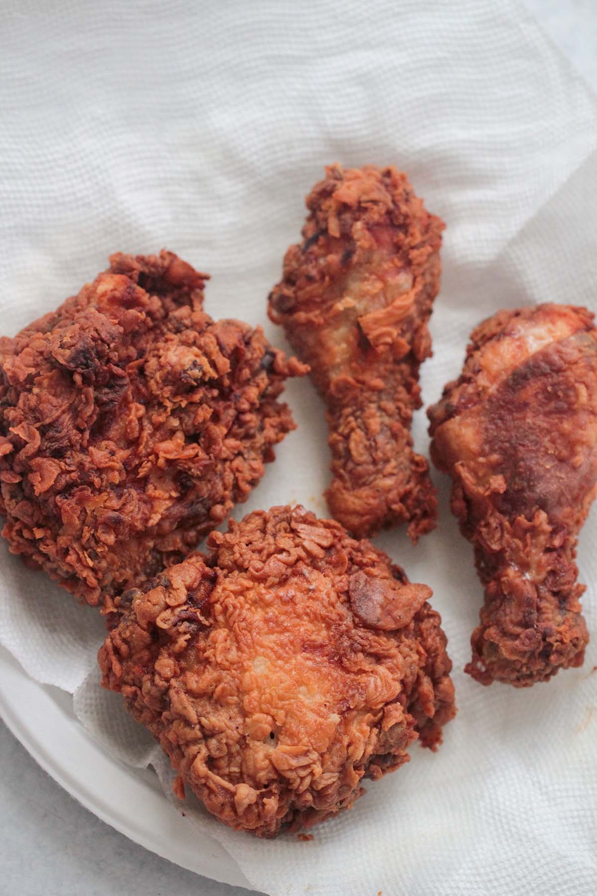 four pieces of fried chicken on a white plate. 