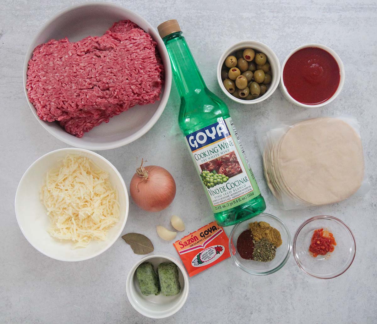 ingredients for empanadas. Beef, olives, cheese, spices, sofrito, cooking wine, onion, garlic, dough, sofrito, chili paste. 