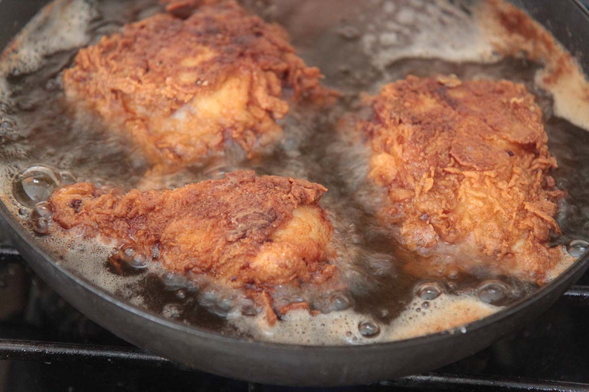 chicken frying in a skillet.