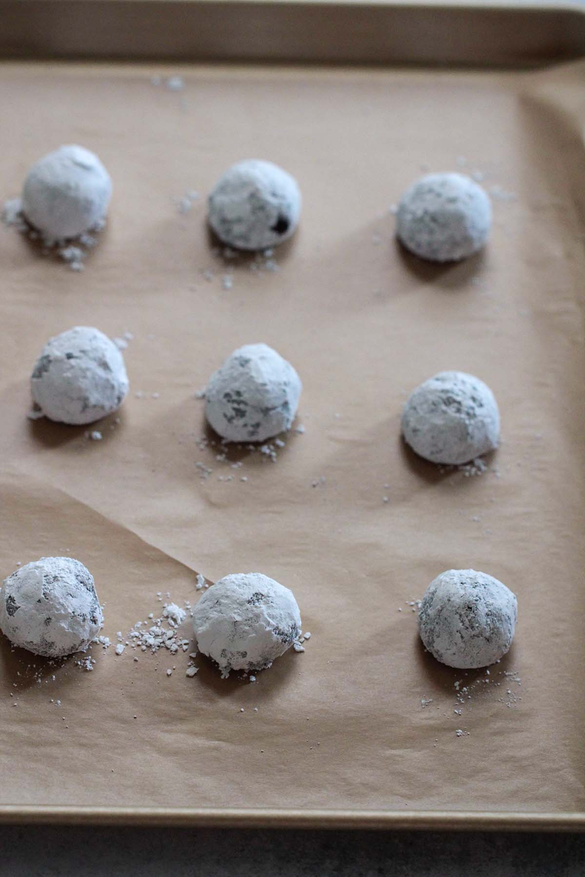 9 cookie balls on a baking sheet.