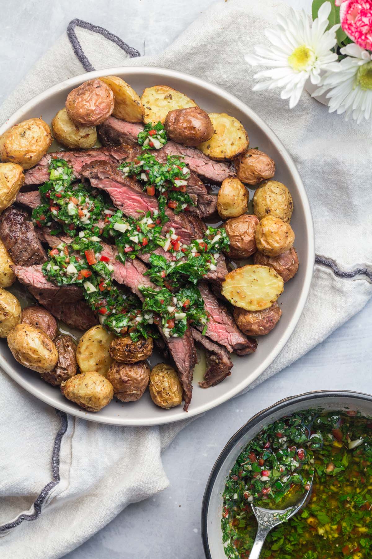 churrasco with chimichurri and potatoes on a plate. 