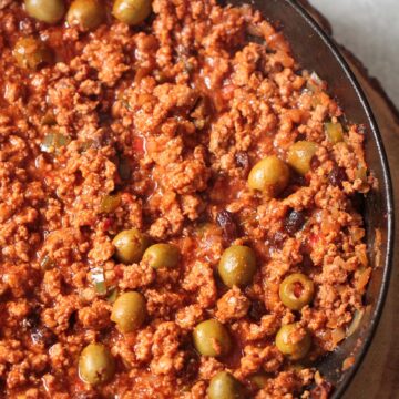 Spicy turkey picadillo in a skillet up close.