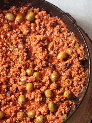 Spicy turkey picadillo in a skillet up close.