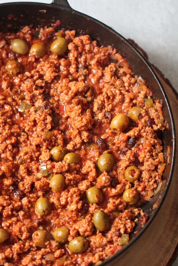 Spicy turkey picadillo in a skillet up close.