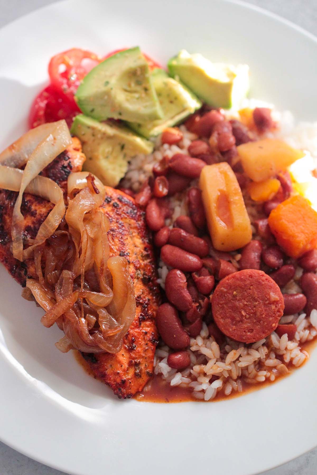 rice, beans, chicken, and avocado salad on a plate. 