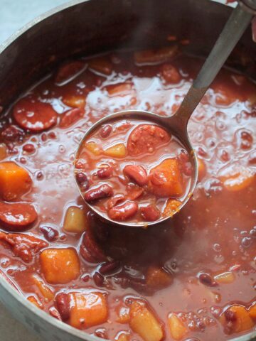 Cuban red beans in a large pot with a ladle.