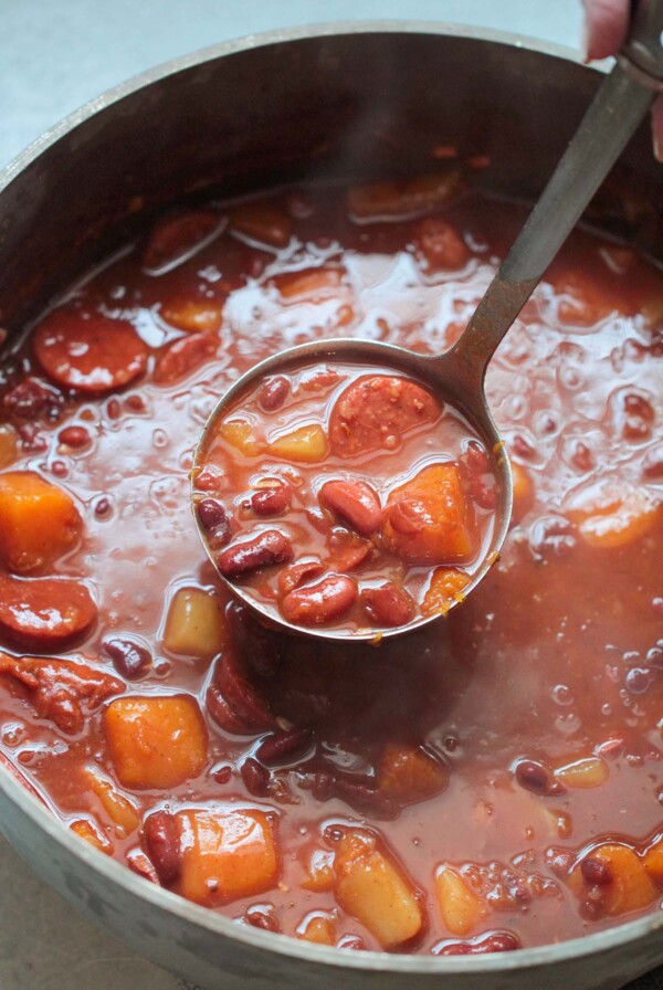 Cuban red beans in a large pot with a ladle.