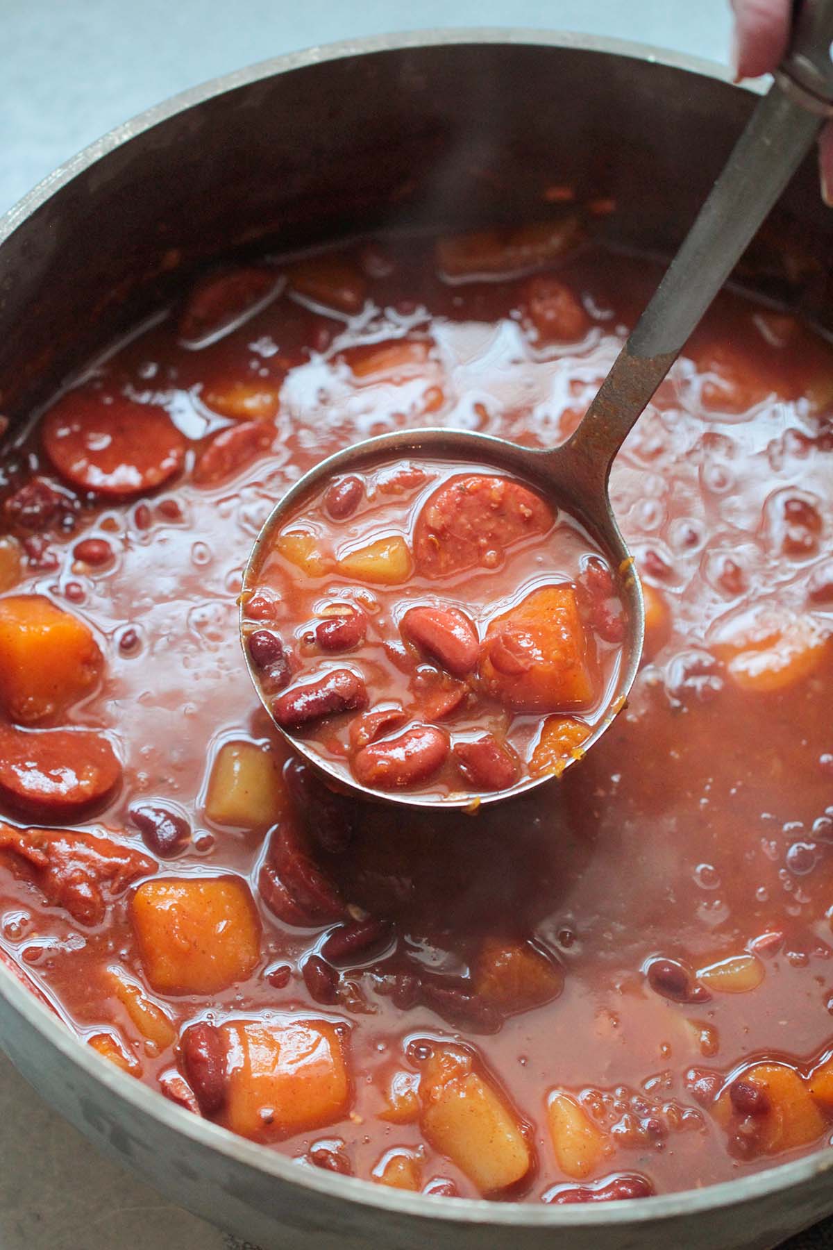 Cuban red beans in a large pot with a ladle. 