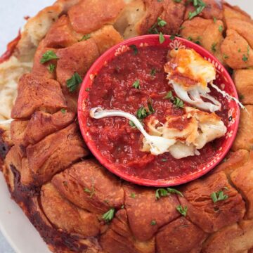 pizza monkey bread with marinara sauce in a bowl.
