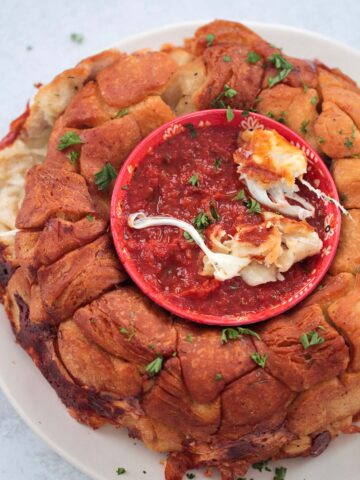 pizza monkey bread with marinara sauce in a bowl.