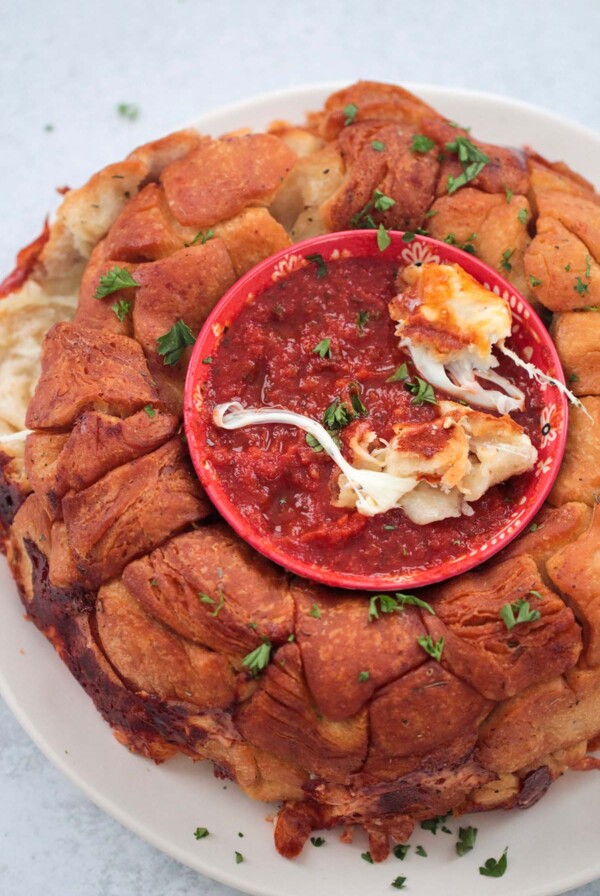pizza monkey bread with marinara sauce in a bowl.