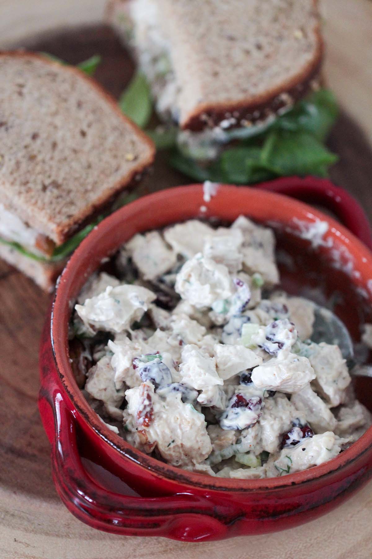 chicken salad in a bowl and sandwiches in the background. 