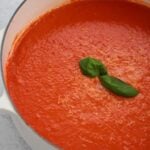 tomato soup in a large white pot.