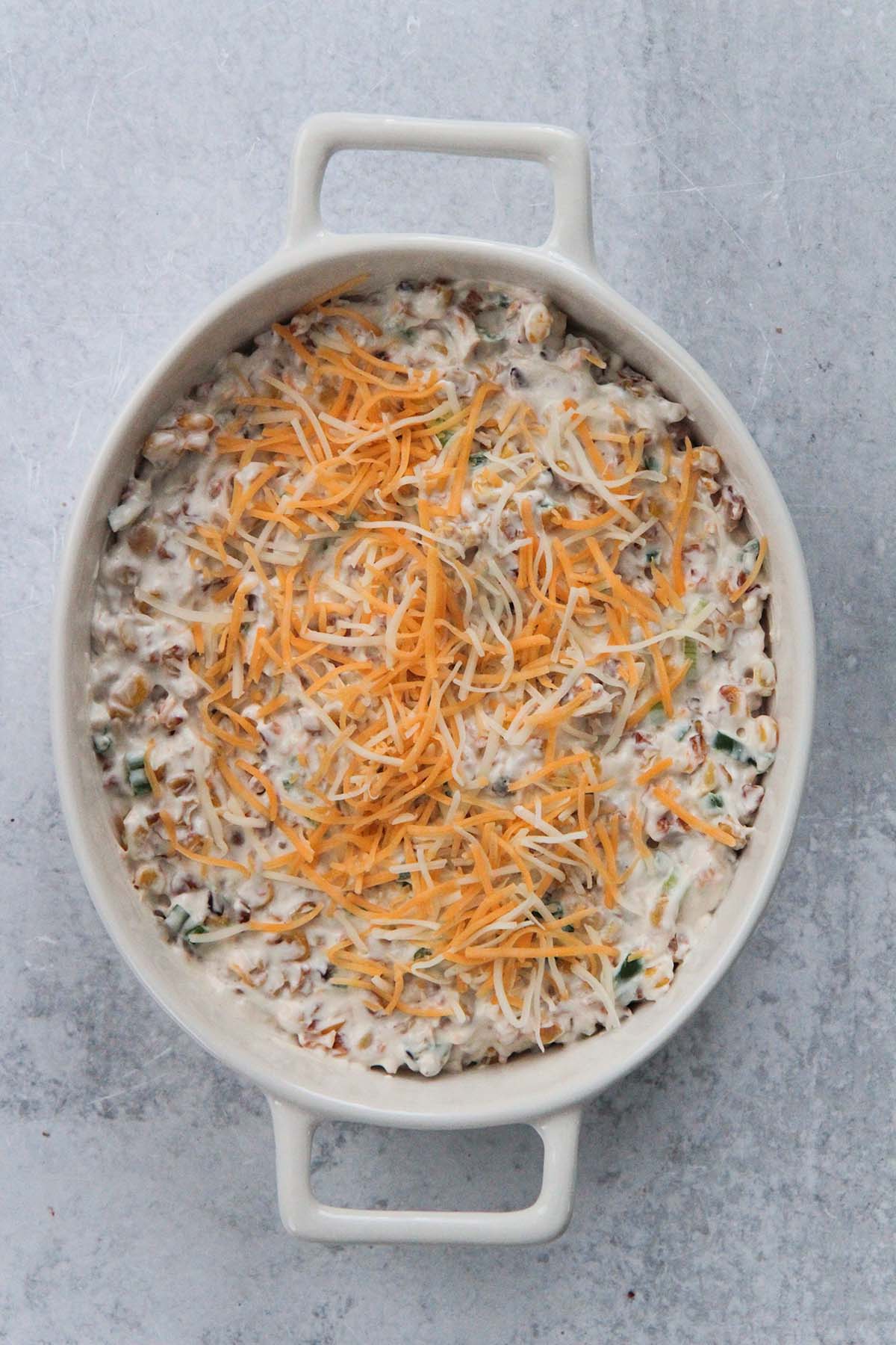 corn dip with shredded cheese on top. 