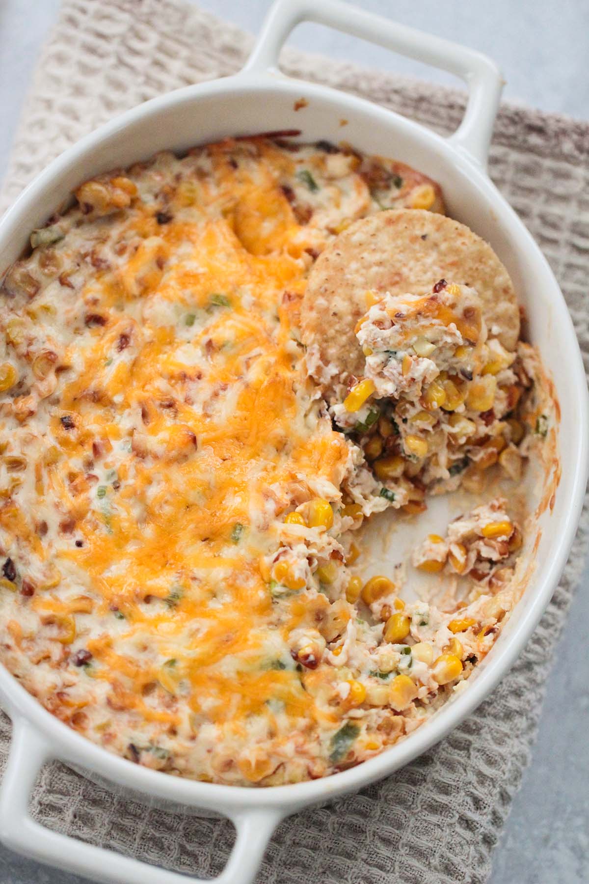 baked hot corn dip with a tortilla chip. 