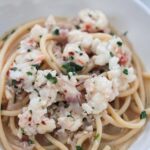 lobster scampi in a white bowl up close.