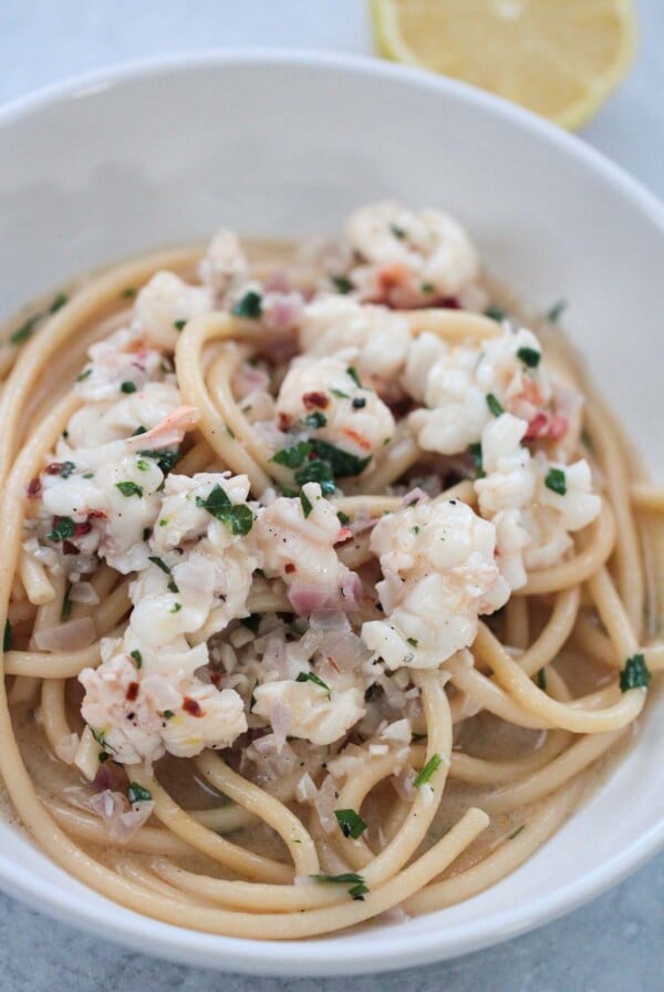 lobster scampi in a white bowl up close.