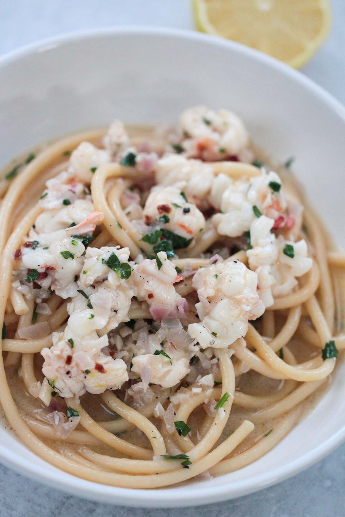 lobster scampi in a white bowl up close. 