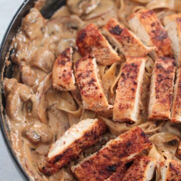 Mushroom chicken fettuccine alfredo in a skillet up close.