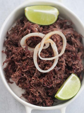 vaca frita with grilled onions and lime wedges.
