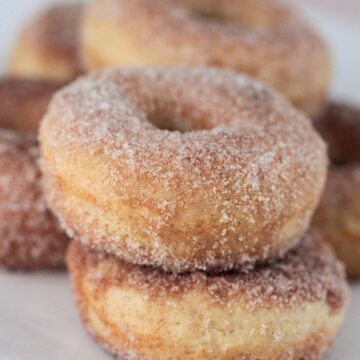 baked cinnamon sugar donuts on a plate up close.