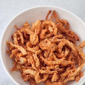 French fried onions in a white bowl.