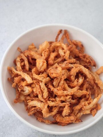 French fried onions in a white bowl.