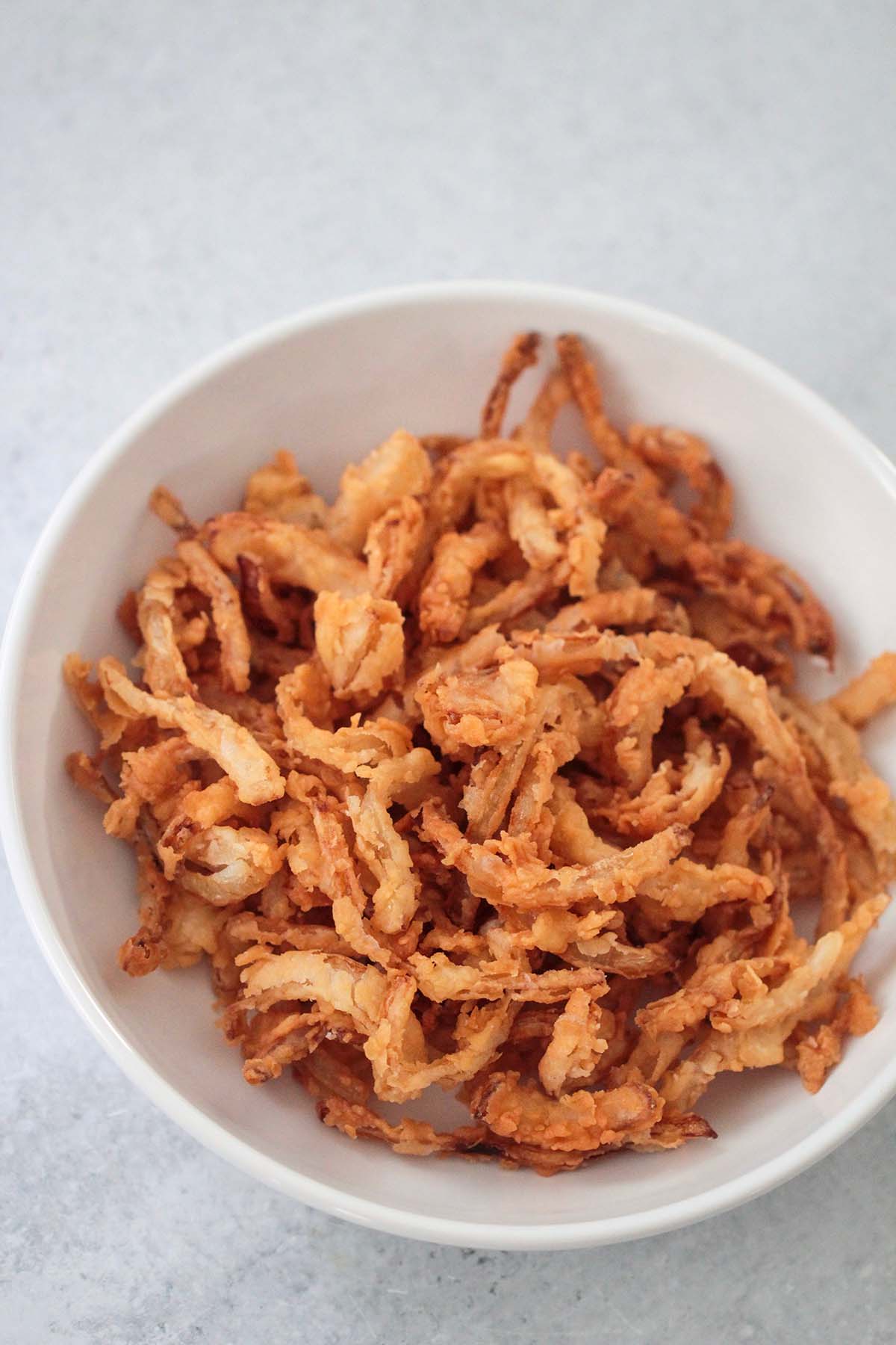 French fried onions in a white bowl. 