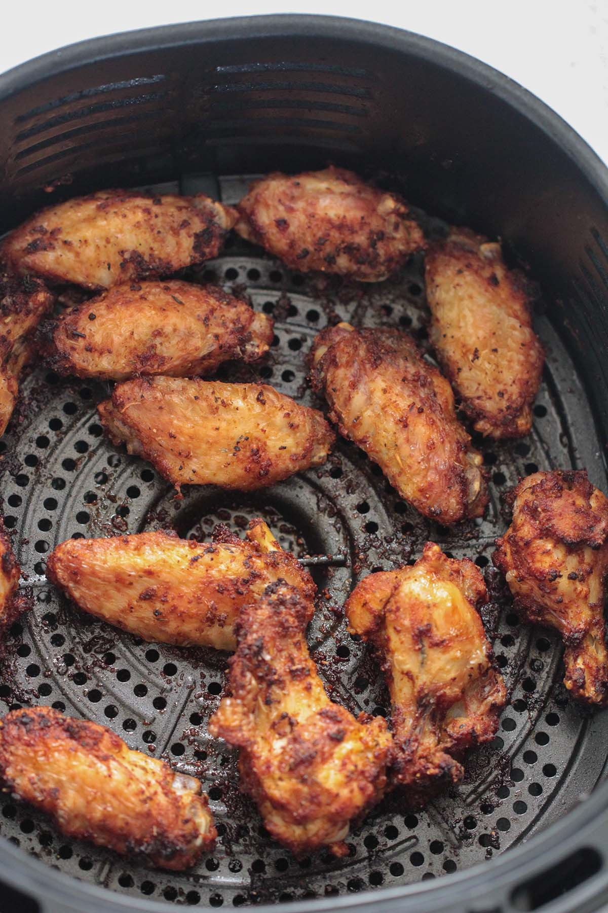 chicken wings in the air fryer basket. 