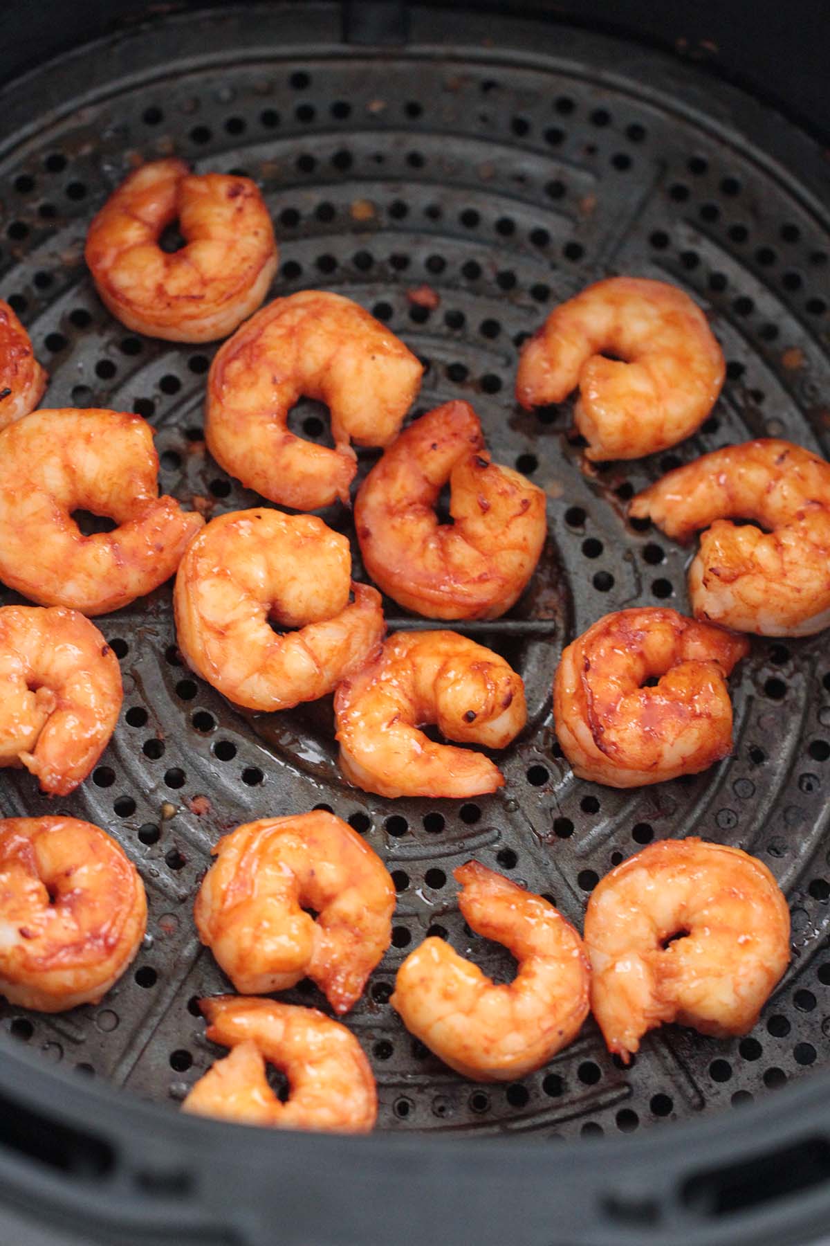 cooked shrimp in the air fryer basket. 