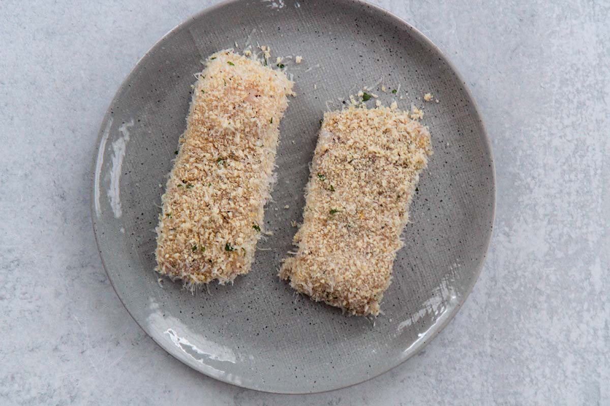 two halibut fillets coated in breadcrumbs. 