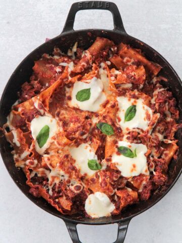 skillet lasagna with melted cheese and fresh basil on top.