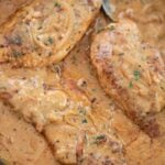 smothered chicken breasts in a skillet.