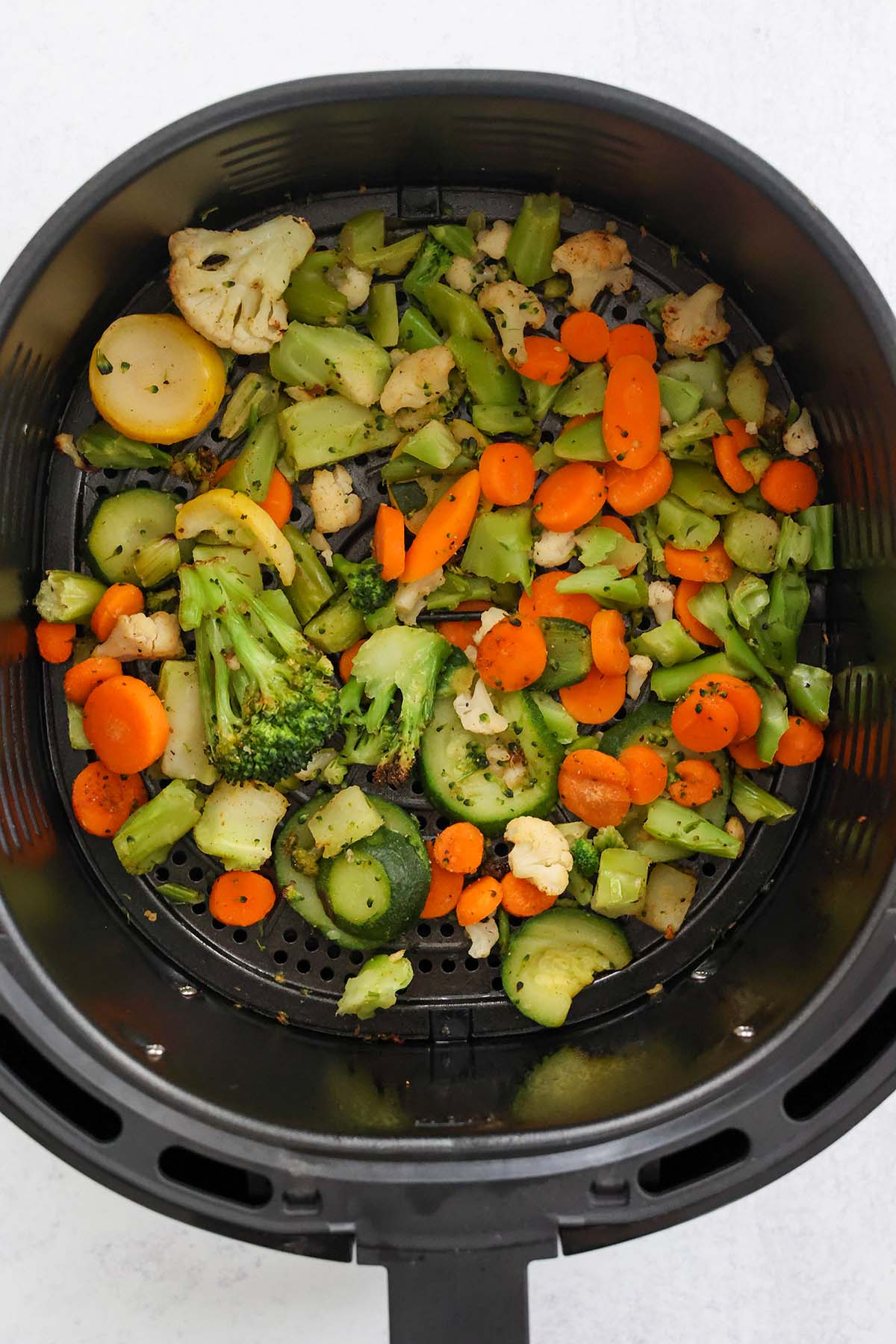 cooked vegetables in the air fryer basket. 