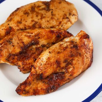 three air fried chicken breasts on a plate.