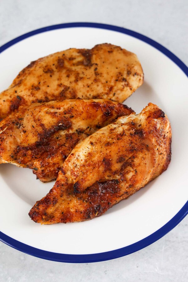 three air fried chicken breasts on a plate.