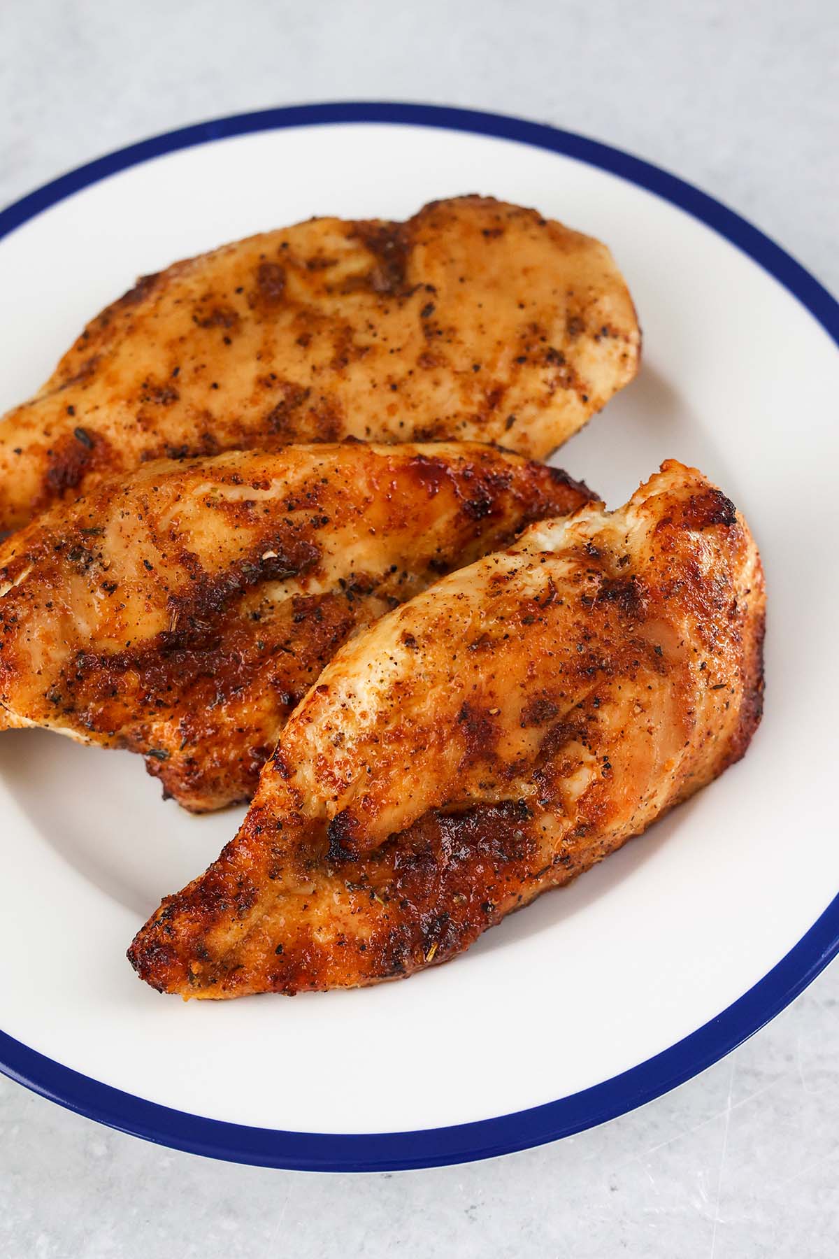 three air fried chicken breasts on a plate. 