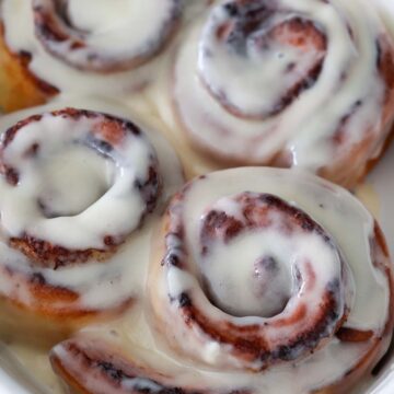 air fryer cinnamon rolls with cream cheese icing on top.