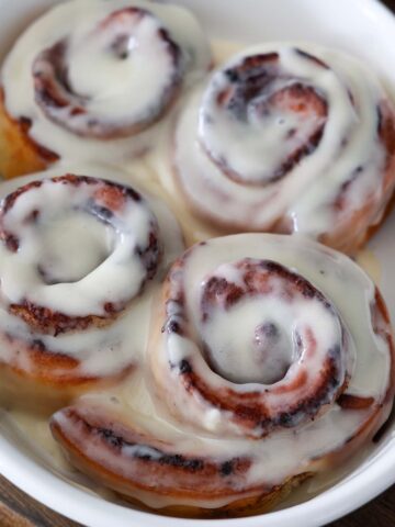 air fryer cinnamon rolls with cream cheese icing on top.