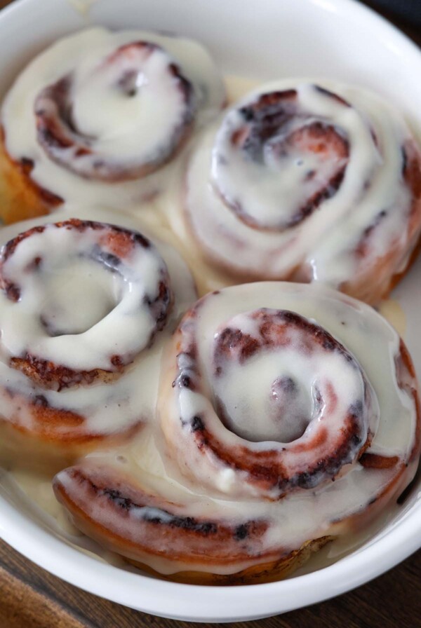 air fryer cinnamon rolls with cream cheese icing on top.