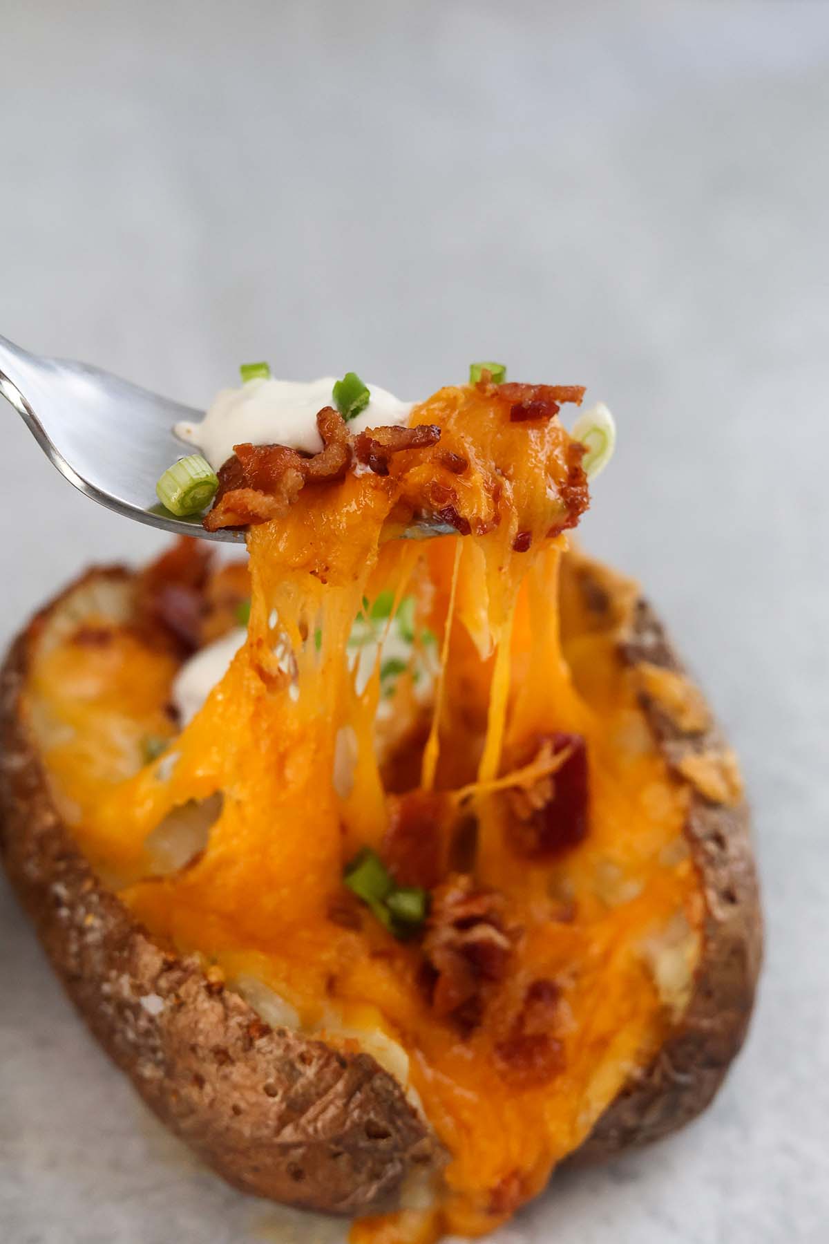 air fryer potato with lots of melted cheese.